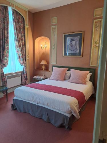 ein Schlafzimmer mit einem großen Bett in einem Zimmer in der Unterkunft Hôtel Particulier des Canonniers in Saint-Quentin
