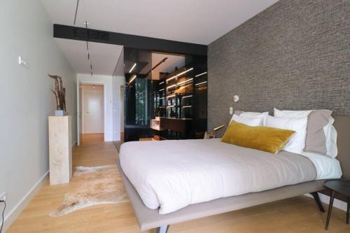 a bedroom with a large white bed with yellow pillows at DOURO VIEWS Luxury Design Beach Apartment in Vila Nova de Gaia