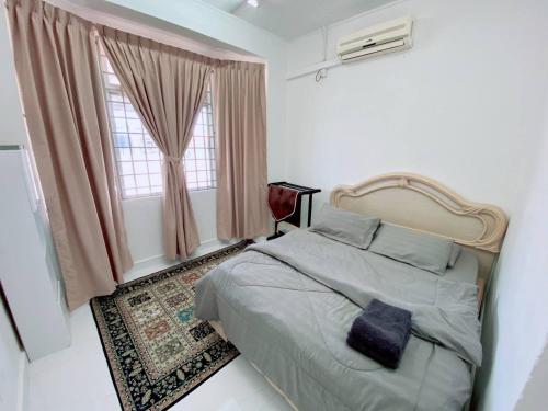 sypialnia z dużym łóżkiem i oknem w obiekcie Homestay Murah Kuala Terengganu w mieście Kuala Terengganu