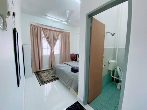 a small bedroom with a bed and a mirror at Grandmaa Homestay, Seberang Takir in Kuala Terengganu