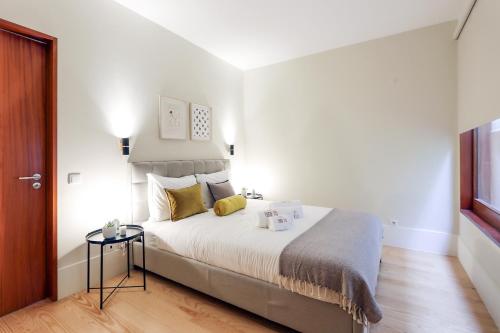 een slaapkamer met een groot bed met gele kussens bij HM - Almada City Stay in Porto