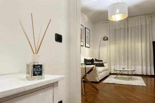 een woonkamer met witte muren en een vaas op een toonbank bij Amazing Flat with Terrace in Milaan