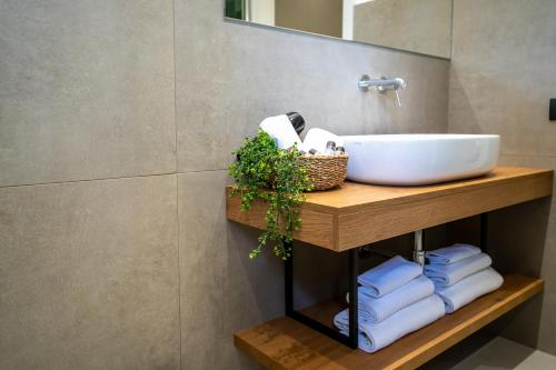 a bathroom with a sink on a wooden shelf with towels at Virdamuri - Etna Country Resort in Giarre