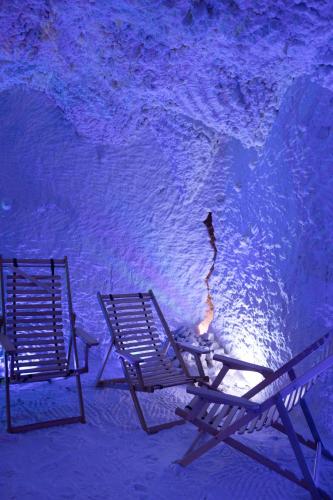 two chairs sitting next to the water at night at VitaPark Stariy Dub in Truskavets