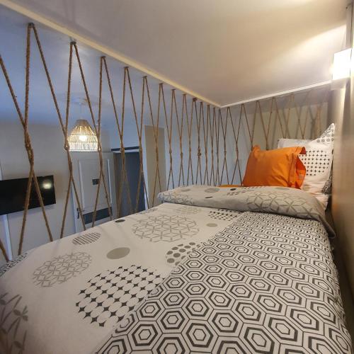 um quarto com uma cama com um edredão preto e branco em À l'aube du sacré coeur em La Plaine des Palmistes