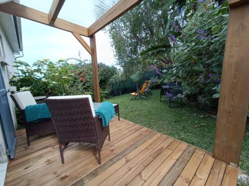 a patio with a table and chairs on a wooden deck at Les barbots in Saint-Louis