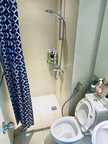 een badkamer met een douche, een toilet en een wastafel bij Azure Urban Residences by C&N in Manilla
