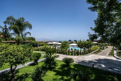 a view of a resort with a pool and trees at Virdamuri - Etna Country Resort in Giarre