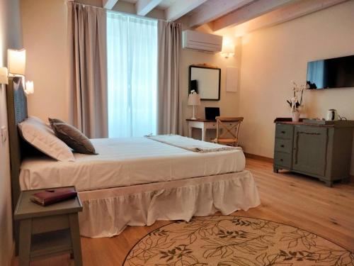 a bedroom with a bed and a dresser and a window at Relais Ca' Morenica in Valeggio sul Mincio
