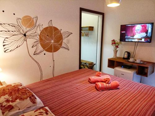 a bedroom with a bed with flowers painted on the wall at Solar das Pétalas Guest House in Florianópolis