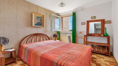 une chambre avec un grand lit et un miroir dans l'établissement La Colinne -113- 3 pers, au Cap d'Agde