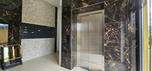 a bathroom with a stainless steel door in a room at Value Living Apartment in Ferizaj