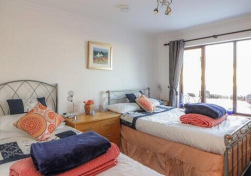 sypialnia z 2 łóżkami i oknem w obiekcie Stunning 7 Bedroom Bungalow Alford Aberdeenshire w mieście Alford