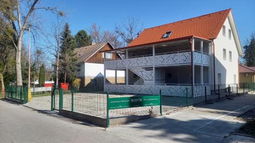 a house under construction with a fence in front of it at apartmánový dom rodiny BÖJTÖS Patince in Virthova Pustatina