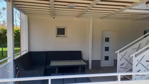 a screened porch with a couch and a table at apartmánový dom rodiny BÖJTÖS Patince in Virthova Pustatina
