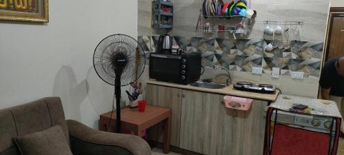 a kitchen with a fan and a counter with a sink at القاهره in Alexandria
