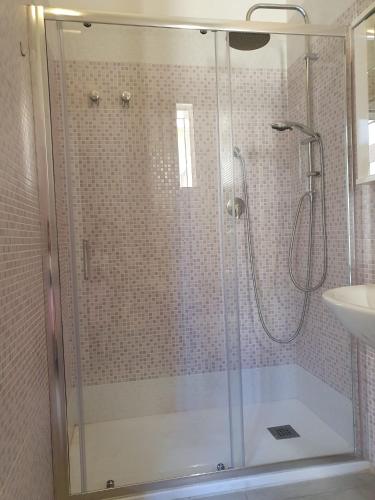 een douche met een glazen deur in de badkamer bij Casa Mari' 1 in Margherita di Savoia