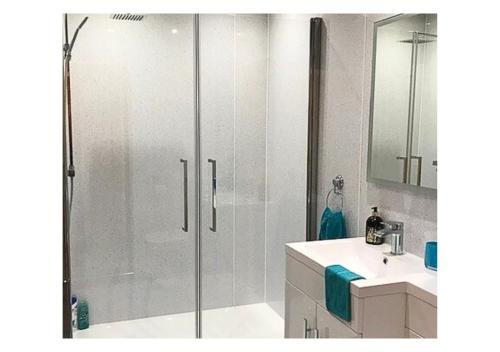 W łazience znajduje się prysznic, umywalka i toaleta. w obiekcie Stunning 7 Bedroom Bungalow Alford Aberdeenshire w mieście Alford