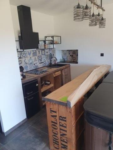 a kitchen with a wooden counter top in a room at Le pré en bulles in Lespesses