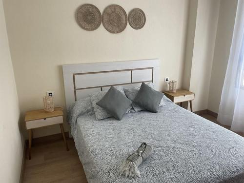 a bedroom with a bed with a pair of shoes on it at Espectacular piso en la playa in Gijón