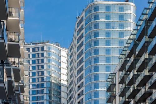 dos edificios altos de cristal en una ciudad en Wola Business Studios Kasprzaka by Renters, en Varsovia