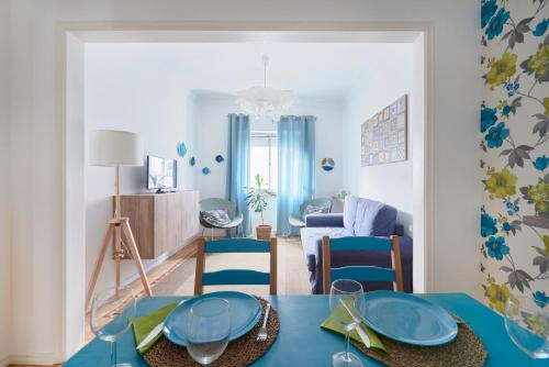 a living room with a blue table and chairs at Bright and quiet apartment in Amadora