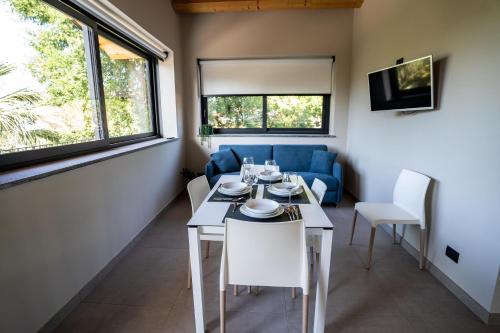 a dining room with a table and a blue couch at Virdamuri - Etna Country Resort in Giarre