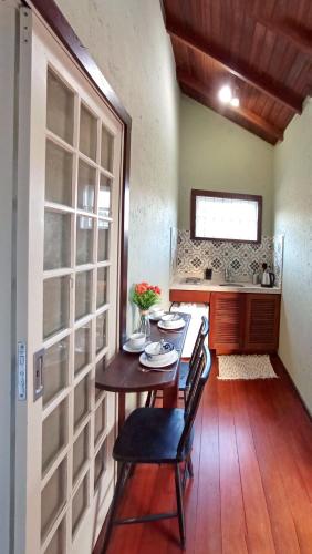 a table and chairs in a room with a kitchen at Solar das Pétalas Guest House in Florianópolis
