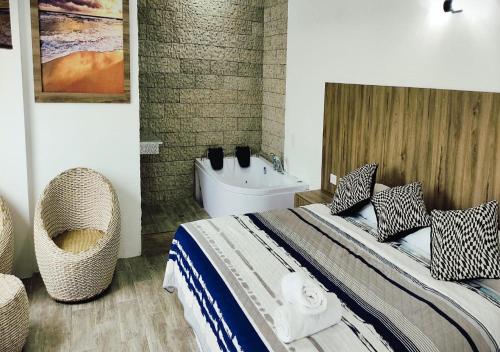 - une chambre avec un grand lit et une baignoire dans l'établissement Terramar Hoteles, à Crucita