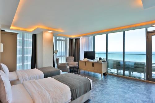 a hotel room with two beds and a view of the ocean at Batumi View Luxury in Batumi