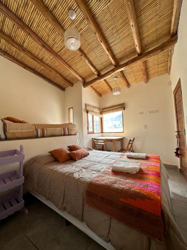 een slaapkamer met een groot bed en een houten plafond bij Las Lavandas Purmamarca in Purmamarca