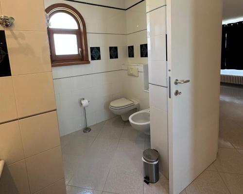 a small bathroom with a toilet and a window at Chiara’s Home in Davoli