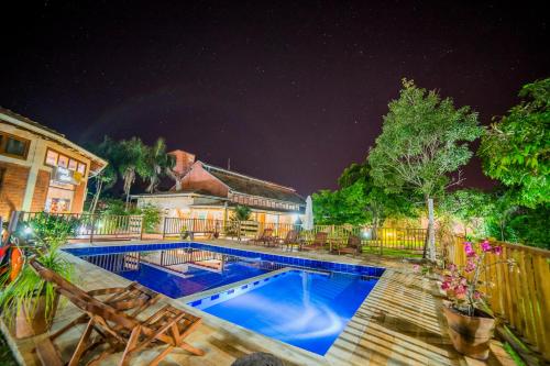 una piscina in un cortile di notte di Pousada Galeria Artes a Bonito