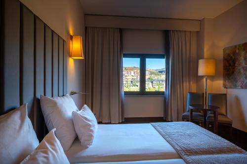 a hotel room with a bed and a window at Vila Gale Collection Douro in Lamego