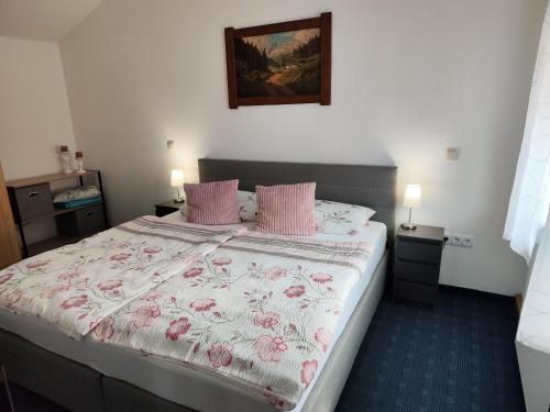 um quarto com uma cama grande e almofadas cor-de-rosa em Ferienwohnung Lay em Hirschaid