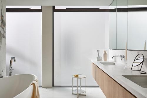 ein Badezimmer mit einer Badewanne und einem Waschbecken in der Unterkunft Casa Tamarama in Sydney