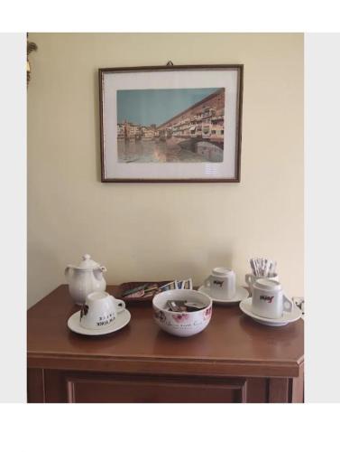 a table with three tea pots and bowls on it at Ivo's villa in Altopascio