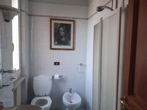 La salle de bains est pourvue de toilettes blanches et d'un lavabo. dans l'établissement Ivo's villa, à Altopascio