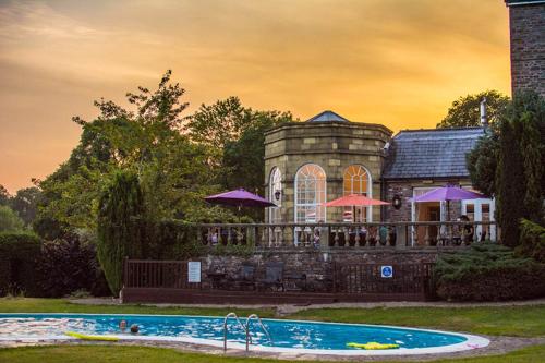 una casa con piscina frente a ella en Peterstone Court Country House Restaurant & Spa, en Brecon