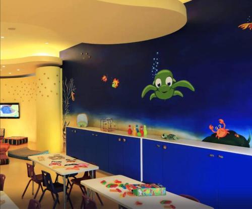 une chambre pour enfants avec un mur bleu et un dessin animé dans l'établissement Departamento Frente a la Playa, Velas Vallarta, à Puerto Vallarta