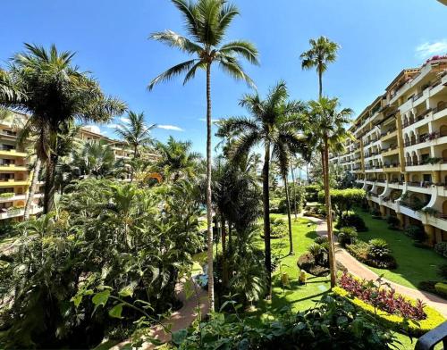 - une vue sur un complexe avec des palmiers et des bâtiments dans l'établissement Departamento Frente a la Playa, Velas Vallarta, à Puerto Vallarta