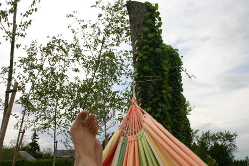 a person laying in a hammock with their feet up at Le Briou in Précy