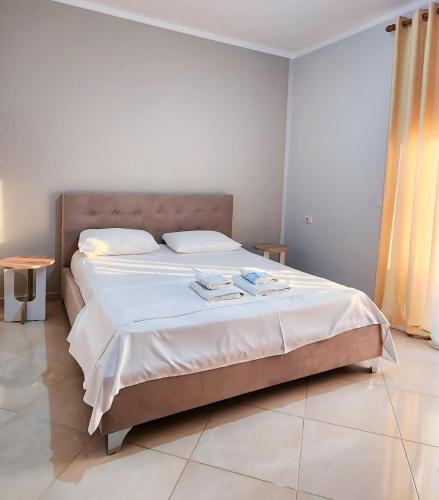 1 dormitorio con 1 cama grande con sábanas blancas en EasySleep at City Center, en Divjakë