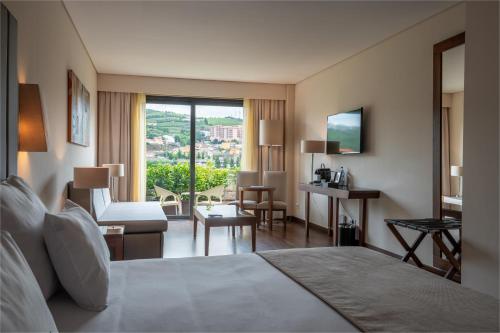 a hotel room with a bed and a living room at Vila Gale Collection Douro in Lamego