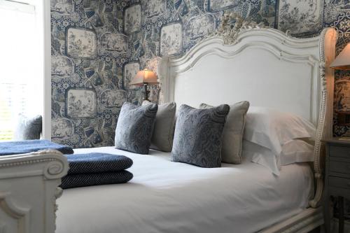 a bedroom with a white bed with blue wallpaper at Padstow Townhouse in Padstow