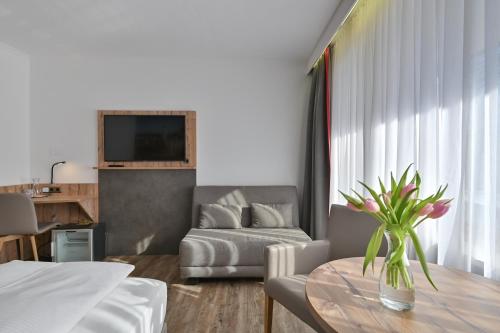 a living room with a table and a couch at Hotel Ruchti - Zeit für mich in Füssen