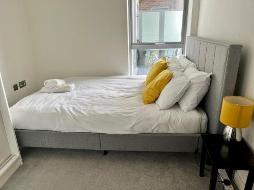 a bedroom with a bed with white pillows and a window at Pass the Keys Central Watford Apartment Sleeps 5 with Parking in Watford