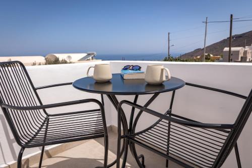 a blue table and two chairs on a balcony at Theophrasti Suites in Foinikiá