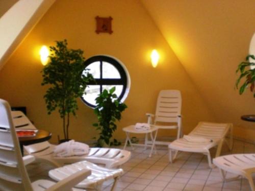a room with white chairs and a round window at Hotel & Restaurant Klosterhof in Dresden