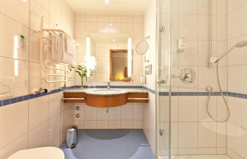 a bathroom with a sink and a shower at Novum Hotel Boulevard Stuttgart City in Stuttgart